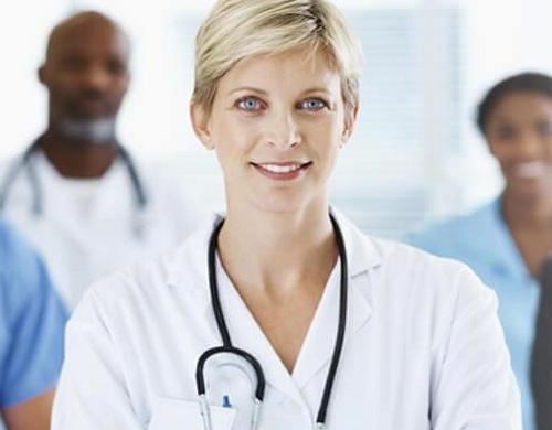 Nurse administrator smiling with other healthcare staff in background